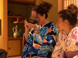 Tea master demonstrating proper technique to attentive students