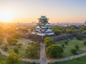 Panoramic morning view of Osaka Castle from park with early joggers