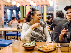Host and guest sharing kushikatsu in a tiny izakaya