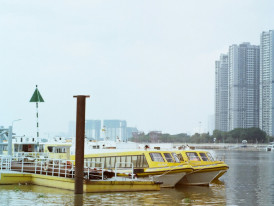 Small boat cruising on Yodogawa River with city skyline Photo by Caroline on Unsplash