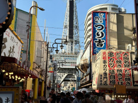Host and traveler standing together at a busy Osaka street intersection Photo by Jeremy  de Blok on pexels