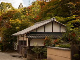 A small traditional tea house with wooden shutters nestled among autumn maple trees Photo Photo by Valeria Gutiérrez: Pexels