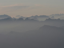 A misty mountain valley in early morning with layers of mountains fading into the distance Photo by Kevin iM on Unsplash