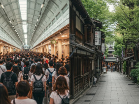 Crowded tourist area with long queues contrasted against an empty local street nearby