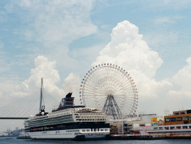 Cruise ship docked at Osaka port with city skyline in background. Photo by Dong In Ham on Unsplash