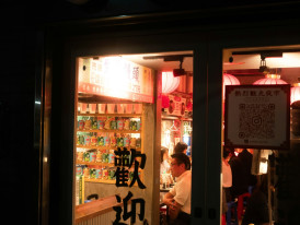 Late-night ramen shop with locals sitting at the counter enjoying bowls of noodles under warm lighting Photo by David Emrich on Unsplash