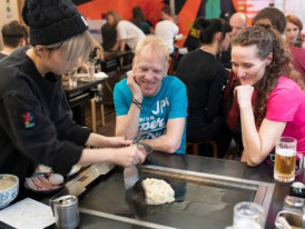 Customer cooking their own okonomiyaki at a teppanyaki table