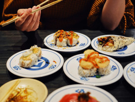 Guest laughing with host over shared dish, both holding chopsticks and enjoying authentic interaction Photo by Frank Pham on Unsplash