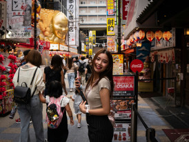 Smiling traveler with host exploring Osaka's traditional backstreets, Photo by Sam Szuchan on Unsplash