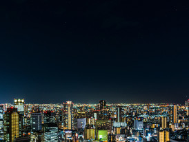 Guest taking photos of Osaka skyline from observatory deck Photo by Hugo WAI on Unsplash