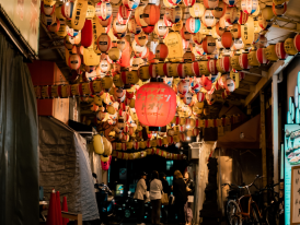 A narrow alley lined with tiny restaurants and red lanterns