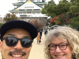 Host and guest pose for a photo