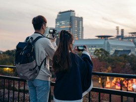 Tourist taking photo at iconic Osaka landmark with guide assisting Photo by Rory McKeever on Unsplash