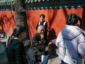 Smiling travelers shaking hands with local guide at meeting point in Osaka, with traditional architecture in background Photo by tommao wang on Unsplash