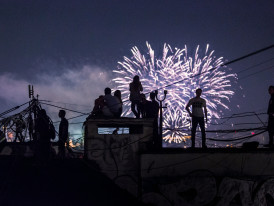  Crowds gathering on rooftops to watch distant fireworks. Photo by Aleksandr Popov on Unsplash