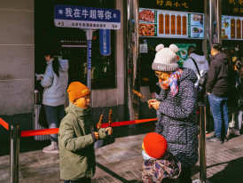 Family laughing at a street snack stand Photo by tommao wang on Unsplash