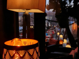 Traditional riverside restaurant with paper lanterns reflected in water at dusk Photo by Stefania Banut on Unsplash