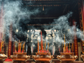 Incense smoke curling through temple courtyard Photo by frank mckenna on Unsplash