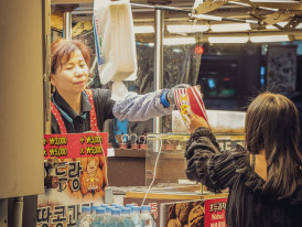 Traveler choosing snacks at a market stall Photo by Justin Bautista on Unsplash