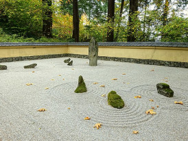 Quiet grounds with lush plantings beside a minimalist rock garden arranged in classic Japanese style
