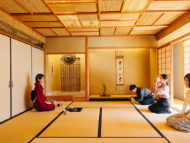 Matcha bowls, whisks, and utensils arranged neatly in a quiet tatami room