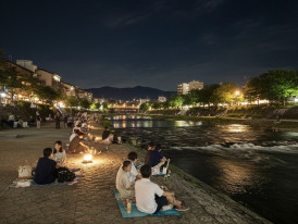 People sitting by the Kamo river at night