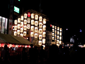 Gion Festival floats illuminated at night. Photo by nekonomania via Wikicommons
