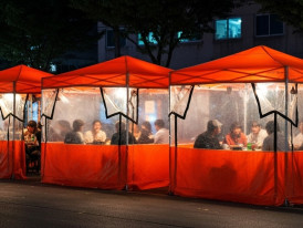 Traditional pocha tent bar with warm lighting and customers inside