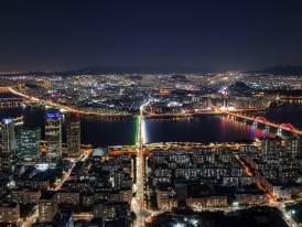 View from Seoul Sky Observatory showing city lights stretching to horizon