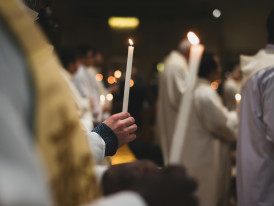 Candlelit religious procession with participants walking at night