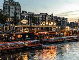 Amsterdam canal at golden hour with bikes lined along the bridge