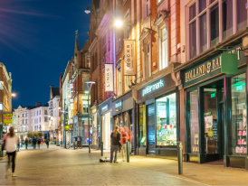 Grafton Street in Dublin city center at night with shoppers walking 