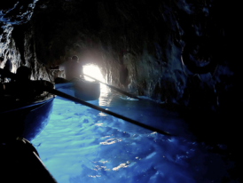 Rowboats at Blue Grotto entrance in calm morning sea