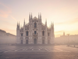 Milan Cathedral spires with soft morning mist and empty square