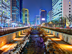 Illuminated Cheonggyecheon Stream with buildings reflected in the water