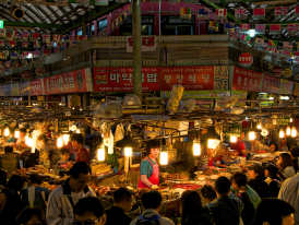 Night scene at Gwangjang Market with vendors working hard 
