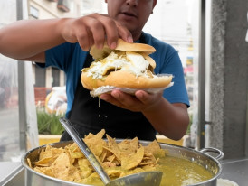 Guajolota - bolillo roll stuffed with a tamal and chilaquiles