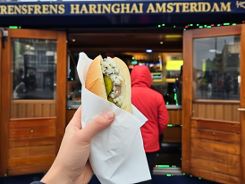 Broodje haring served at Frens Haringhandel near Koningsplein, with diced onions and pickles