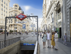 Friends walking down Gran Vía at dusk
