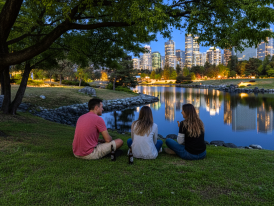 Friends at Habitat Island with downtown skyline reflected in False Creek