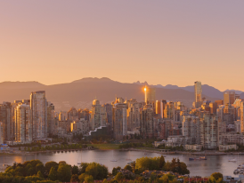 Vancouver skyline transitioning from golden hour to night with mountains and ocean