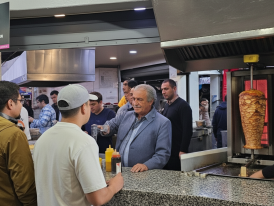 Taco stand with long line of hungry people