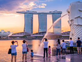 Merlion statue facing Marina Bay with Marina Bay Sands in the distance at dusk