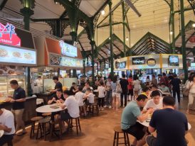 Busy hawker stalls with people ordering lunch at a food center