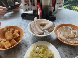 A bowl of peppery bak kut teh with fried dough on the side