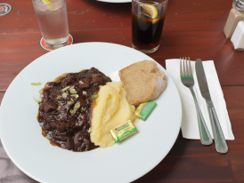 Bowl of Irish stew with brown soda bread on a wooden table