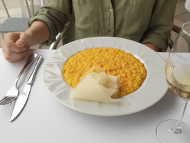 Golden saffron risotto served in traditional Milanese trattoria setting