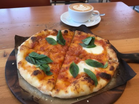 A gluten-free pizza with a crispy crust, fresh toppings, and melted cheese