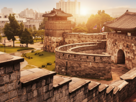 Suwon Hwaseong fortress wall at golden hour with locals walking