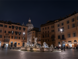 Piazza Navona fountain lit up at night with the surrounding baroque architecture